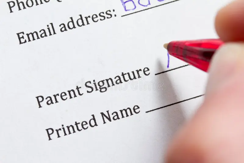 Parent signature form with pen showing parental consent documentation for minor children activities and travel
